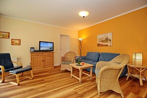Wohnzimmer mit Sitzecke, Kommode und TV