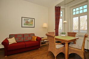 Wohnzimmer mit Schlafcouch und Esstisch