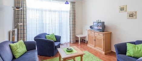 Wohnzimmer mit Schlafcouch und TV