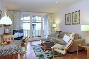 Wohnzimmer mit Schlafcouch und TV