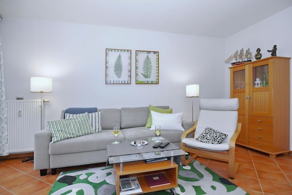 Wohnzimmer mit Schlafcouch und Sessel