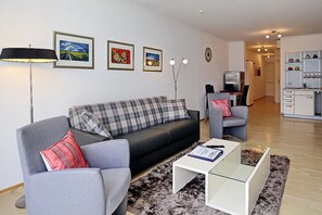 Wohnzimmer mit Schlafcouch und Sesseln