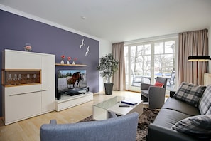 Wohnzimmer mit Schlafcouch und TV
