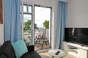 Wohnzimmer mit Schlafcouch und TV