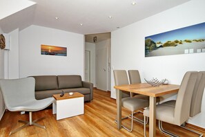 Wohnzimmer mit Schlafcouch und Esstisch