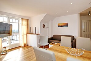 Wohnzimmer mit Esstisch und TV