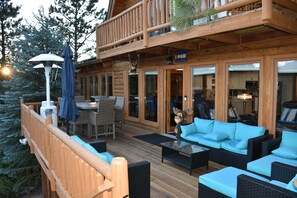 Large main deck with front door entrance. Balcony above connects to two bedrooms
