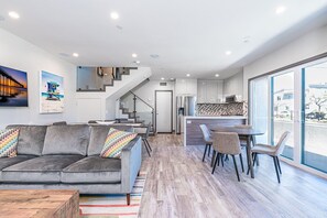 View of the ground floor from the front door, with an open floor plan between kitchen and living areas. Back door (pictured) leads to garage.