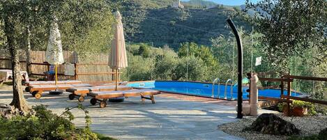 Piscina con lettini immersi nel verde circondati dal prato