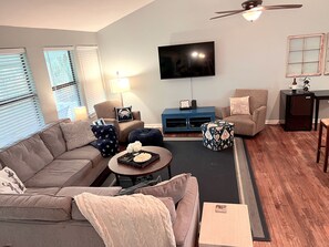 Large living room with TV that has multiple streaming services