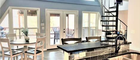 View from the kitchen . . . looking at the dining area and back deck outside. 