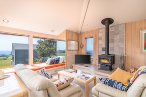 Ocean view living room with fireplace, Smart TV and window seating