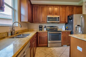 The Kitchen Features Hardwood Cabinetry, Stainless Appliances and Granite Counter Tops