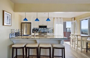 Generous, open concept kitchen with bar stools to also eat at the countertop