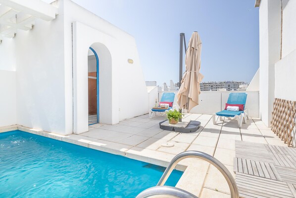 Terrasse sur le toit avec chaises longues et piscine