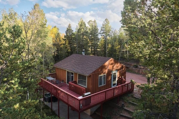Private cabin in forest with wraparound deck.