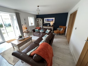 Fabulous spacious cosy lounge with coffee table and doors opening to the garden