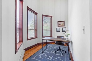Well lit work area with desk and chair.