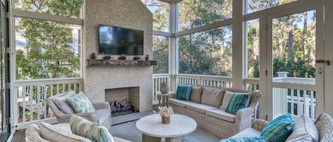 Gather 'round the fireplace with your friends in the screened in porch complete with lounge and smart Tv.