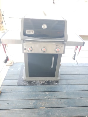 Weber 3 burner grill with a spare tank located in the shed