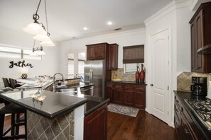 Kitchen with breakfast table that seats 6 and bar stools at the counter 