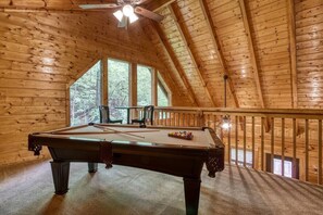 Loft with pool table and seating for two.