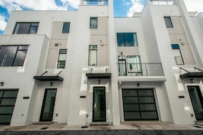 Exterior of condos with view of courtyard and garages