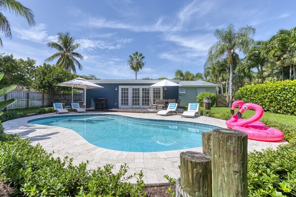 Relaxing family friendly 3-bedroom & 2-bathroom Villa situated between Palm Beach and Jupiter features a large, tropical, outdoor entertainment space with large pool, BBQ Gas Grill, patio dining and lounging and Cornhole