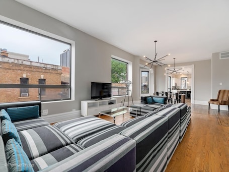 Living room with bright windows and seating for everyone on a huge couch. Flat screen TV with cable and smart TV options. Living room leads to the open dining/kitchen area an for ideal entertaining setup for all your friends and family.