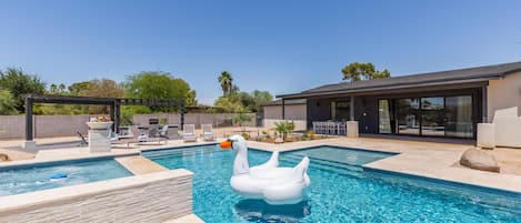 Backyard Resort featuring a sparkling blue oasis and spa, BBQ grill, Covered Patio w/ Outdoor Dining, fire pit and a Sports Court!