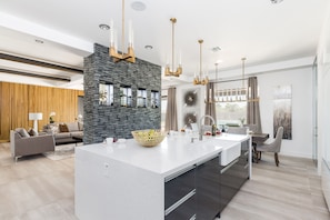 Fully Equipped Chefs Kitchen stocked with all culinary essentials, and stainless steel appliances. Features an oversized island with breakfast bar seating.