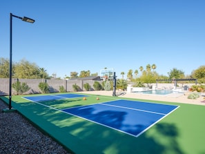 Backyard Resort featuring a sparkling blue oasis and spa, BBQ grill, Covered Patio w/ Outdoor Dining, fire pit and a Sports Court!