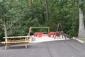 Outdoor fun includes fire pit, swing, charcoal grill, picnic table & cornhole