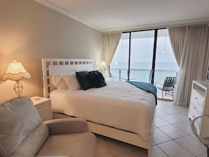 Bedroom with king size bed, large screen tv, recliner, and balcony