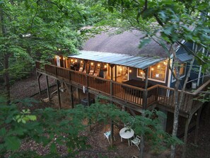 Covered rear deck with grill, rocking chairs and dining table. 