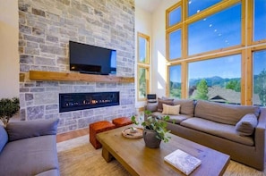 The living room boasts abundant natural light, a welcoming fireplace, and direct access to the balcony.