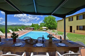 The property and  equipped pergola for dinner close the pool