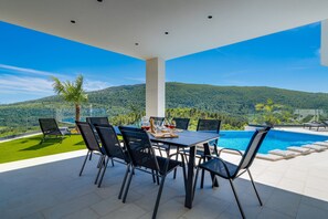 A covered terrace with a comfortable outdoor dining area