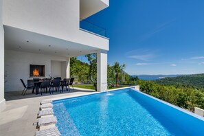 An outdoor dining area, and a traditional barbecue next to it