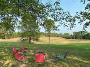 View looking east from the cottage toward a large field and a filling pond