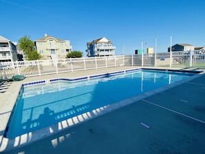 Community pool and tennis court across street from house 