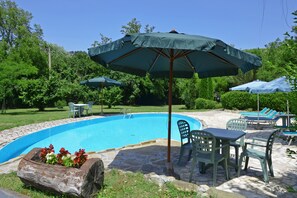 Das Schwimmbad, das von der Sonnenterrasse und der Grünanlage umgeben ist