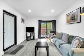 Serene and inviting living area with cushy seats, a coffee table, and seamless access to your own balcony