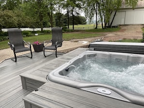 The 6 person hot tub with deck surround overlooks the beautiful backyard. 