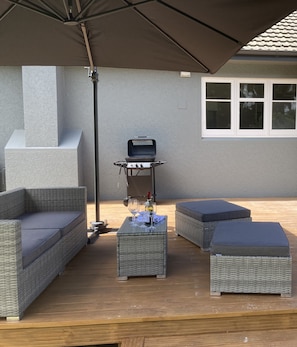 Outdoor furniture on the deck including sunbrella.