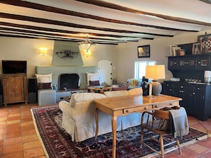 Formal living area with work desk and massive adobe fireplace
