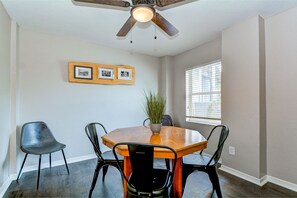 The dining room has a tree feel to it with the wood table and nature pictures.