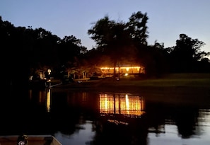 Evening view of the lit up house from the lake
