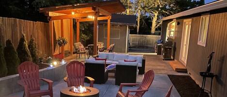 Outdoor area with Trellis, Couch, Fire-pit, tree-swing and landscape lighting.