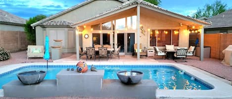 Enjoy the serene backyard and its many amenities: pool, fire pit, BBQ, daybed, and eating area